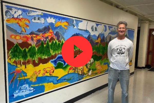 Paul Blumenthal posing in front of a mural.